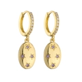 Vue détaillée des boucles d'oreilles dorées avec zircons et gemmes violettes en étoile - Pendentif Ovale en Strass Violet
