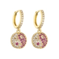 Détail de boucles d'oreilles dorées avec pendentif Yin Yang pavé de zircons roses - Pendentif Tai Chi en Strass Rouge et Blanc