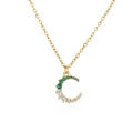 Primer plano de un collar dorado con colgante de luna y piedras de circonita finas - Luna Verde y Blanca