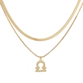Detailed macro of golden Libra constellation pendant on layered herringbone snake chain - Gold Libra