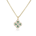 Macro shot of a clover pendant necklace featuring green gemstones and white crystals - Gold Green Clover