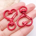 Macro-opname van rode hartvormige zinklegering karabijnhaak voor DIY-sieradenhangers - Rood