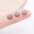 Retro black flower hollow metal bead caps for DIY jewelry making shown on fingertip - 7mm / Gunmetal