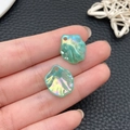 Two iridescent mint green acrylic leaf charms with drill holes held in hand - Iridescent Mint Green Cabbage Leaf (22000)