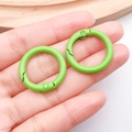 Primer plano de anillas de resorte de 24mm verde hierba con acabado mate para manualidades - Verde