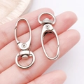 Set of two silver swivel lobster clasps for DIY keychains and bags shown in hand - White K Cable Clasp Keychain (13x37-13020)