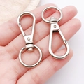 Two silver metal lobster clasps with swivel rings on hand for keychain DIY accessories - White K Flat Clasp Keychain (13x42mm-13018)