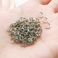 Polished silver alloy jump rings for DIY keychain making shown on palm for scale - White K Iron Round Jump Rings (0.9x6mm-12971)
