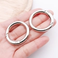 Two polished silver zinc alloy spring rings for bags and keychains held in hand - 35mm / White Gold