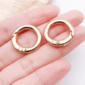 Two rose gold metal spring carabiner rings for handbags shown in a hand - 20mm / KC Gold