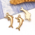 Detailed close-up showing golden dolphin pendants with high-gloss mirror finish metal texture - Small Dolphin (T3035)