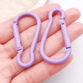 Pair of purple matte finish gourd-shaped aluminum carabiners held in hand for scale - Purple (26206)