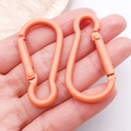 Pair of orange matte calabash carabiners held in hand for scale and detail - Orange Yellow (26210)
