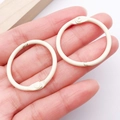 Cremeweißer 30mm Buchring aus Metall mit Scharnier für DIY-Projekte in der Hand - Milchweiß