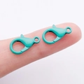 Pair of mint green painted zinc alloy lobster clasps shown on finger for scale - Cyan (14x8mm)