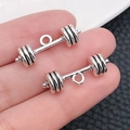 Macro shot of antique silver dumbbell charms for DIY jewelry held in hand - Dumbbell Training Style (9014)