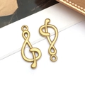 Detailed macro view of gold-plated treble clef music note pendants for DIY jewelry crafting - Music Symbol (T2843)