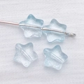 Macro detail of 8mm light blue star-shaped glass spacer beads with translucent icy texture - Transparent Blue