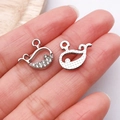 Macro shot of silver whale charm pendants with crystals held on a fingertip for size - White K Rhinestone Whale / 14x15mm