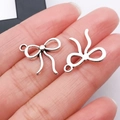Ciondoli a fiocco in metallo argento per gioielli fai-da-te mostrati in primo piano - 15x16mm / Fiocco Cavo Argento Antico (26990)