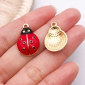 Pendentif coccinelle rouge et noir pour bijoux DIY présenté dans la paume de la main - Coccinelle Émail Rouge 22x14mm