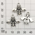 Detailed macro view of vintage silver bee charms on a metric measurement grid - Bee Style (9188)