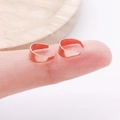 Bagues d'oreilles minimalistes en or rose poli, présentées sur les doigts pour la taille - Or rose