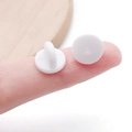 Coppia di chiusure a farfalla bianche tonde in silicone per spillette mostrate su un dito - Bianco
