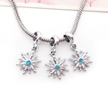Macro shot of silver snake chain bracelet featuring three blue crystal snowflake pendants - Blue Snowflake Pendant (15208)