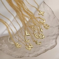 Collane con lettere 3D dorate e catena a sfere su un vassoio di vetro - Lettera A / Oro