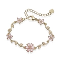 Macro detail of gold flower bracelet featuring pink zircon petals and leaf-shaped metal links - Gold Tone Pink Zirconia Flower Leaf Bracelet
