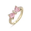 Detailed macro view of an adjustable gold ring with a pink crystal bow design - Gold Pink Zirconia