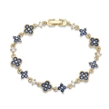 Detailed close-up of golden clover bracelet with inlaid blue and white crystals - Gold Plated Blue Zirconia