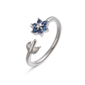 Macro view of adjustable silver ring featuring blue sapphire flower and polished leaves - Platinum Blue Zirconia Flower Ring