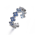 Macro detail of silver four-leaf clover ring with blue crystals and open adjustable band - Platinum / Blue Zirconia