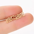Macro shot of gold Gothic 1982 number earring held by hand to show compact size - 1982 Gold