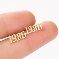 Detailed view of gold 1986 gothic font earring held to show size and polished finish - 1986 Gold
