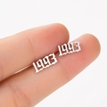 Macro detail of custom 1993 year stud earring in silver gothic font stainless steel - 1993 Silver