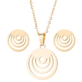 Flat lay of golden geometric jewelry set with circular pendant and matching stud earrings - Gold