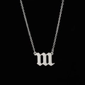 Detail of gothic silver letter m pendant with brushed metal texture on a fine chain - 111 Steel Color
