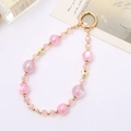 Pink crystal beaded phone charm with golden butterflies and iridescent beads on white background - Pink