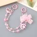 Pink beaded phone charms with butterfly bows and heart pendants on a grey backdrop - Pink