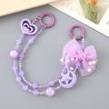 Detail of purple beaded phone charm with layers of crystal beads and a large tulle bow - Hand Chain / Purple