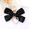 Détail d'un nœud en satin noir avec un pendentif cœur doré serti de perles - Noir