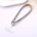 Nahaufnahme der glitzernden Silber-Strass-Handschlaufe mit Metallring und weißem T-Patch - Weiß