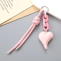 Close-up of pink woven leather strap with heart pendant and silver metal ring accessory - PU Cord + Heart Pendant / Pink