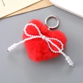 Close-up of red faux fur heart keychain with white faux pearl bow and silver metal ring - Red