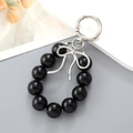 Llavero de moda con cuentas negras y colgante de lazo plateado para bolsos - Lazo Cinta Negro Adorno Cuentas