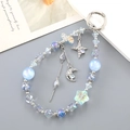 Detail of star and moon charms on a beaded strap with iridescent acrylic and blue glass beads - Blue