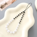 Elegante telefoonkoord met parels en diamanten ring op een crèmekleurig dienblad - Zwart